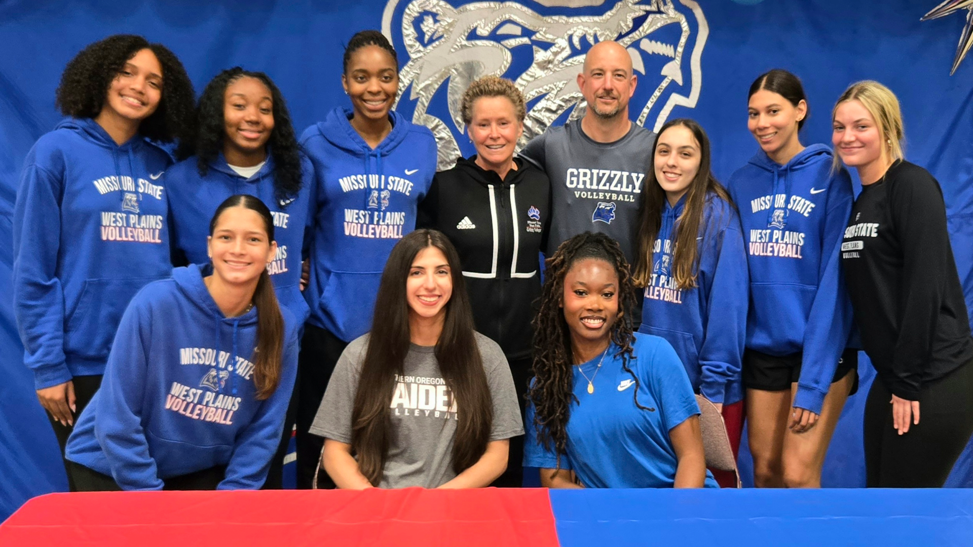 Women's Grizzly Volleyball team surrounding their team mates who signed letters of intent.